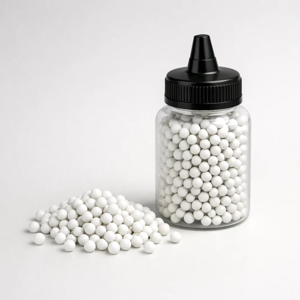 A pile of generic airsoft BBs beside an unbranded container
