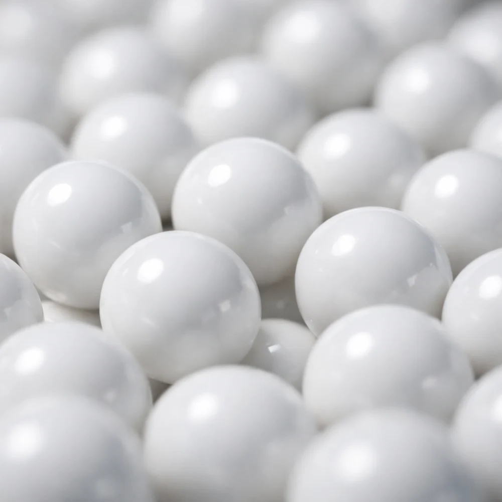 Close-up of several airsoft BBs grouped together on a plain surface.
