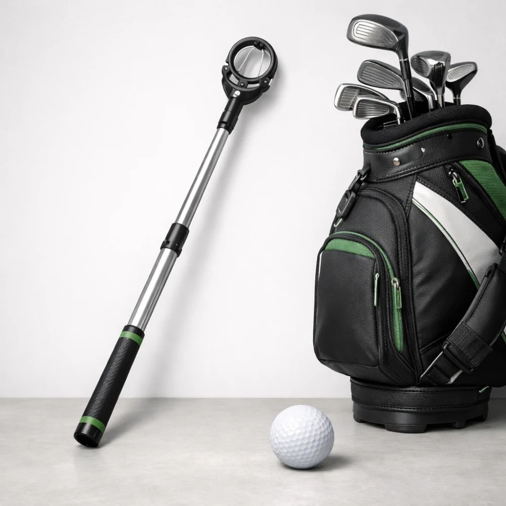 A golf ball retriever beside a golf bag and golf ball